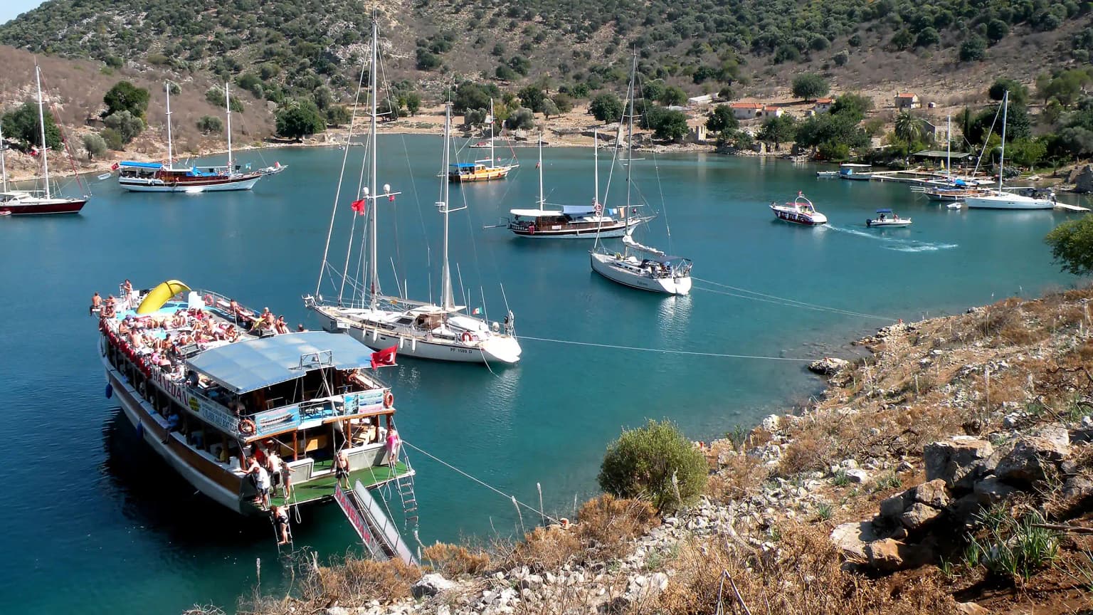 Ein Sonntags-Ausflugsboot ankert in der Winterbucht der Insel Tersane, Göcek. Eine historische Bucht, die ein häufiger Anlaufpunkt für Blaue Reise-Boote und tägliche Touren ist.