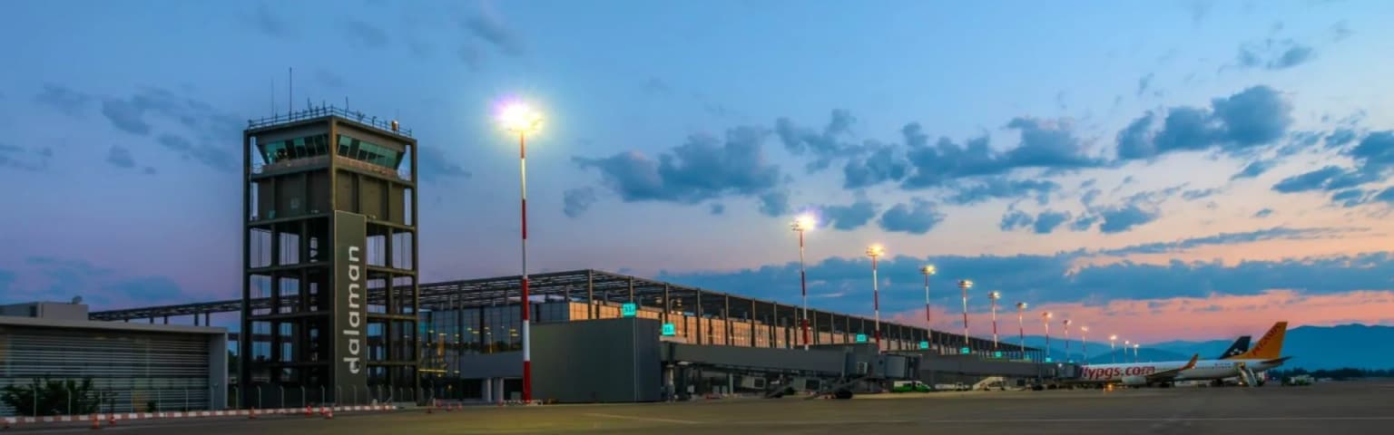 The modern exterior terminal building of Dalaman Airport (DLM). The international gateway to tourist destinations like Fethiye, Gocek, and Marmaris.