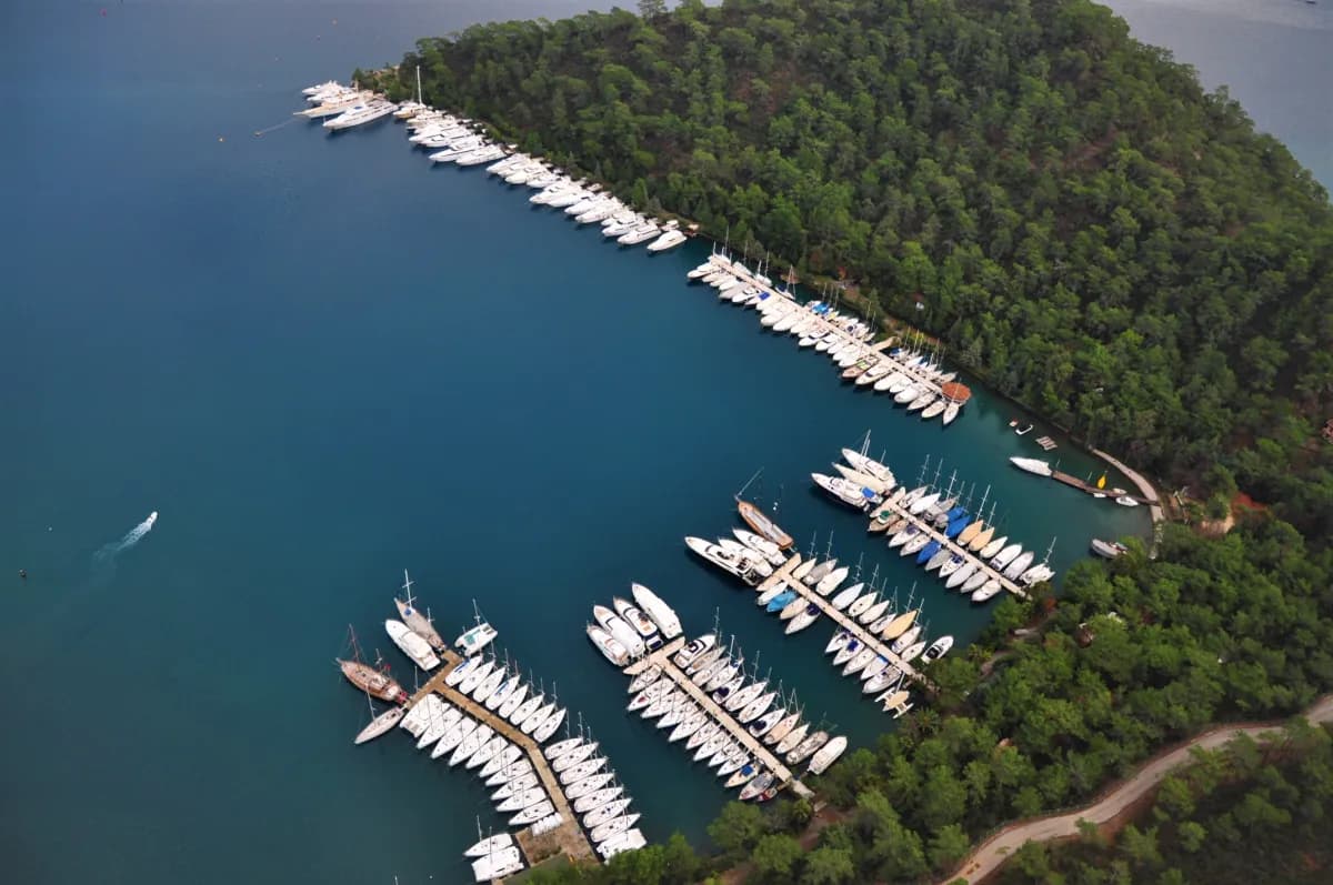 Club Marina and its facilities, nestled on a lush green hillside in Gocek. A calm and exclusive accommodation and mooring experience in nature.