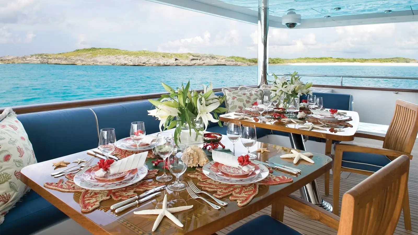 A stylish dinner table set against the Aegean Sea view on a blue cruise. Gourmet flavors and a delightful dining experience on a boat.