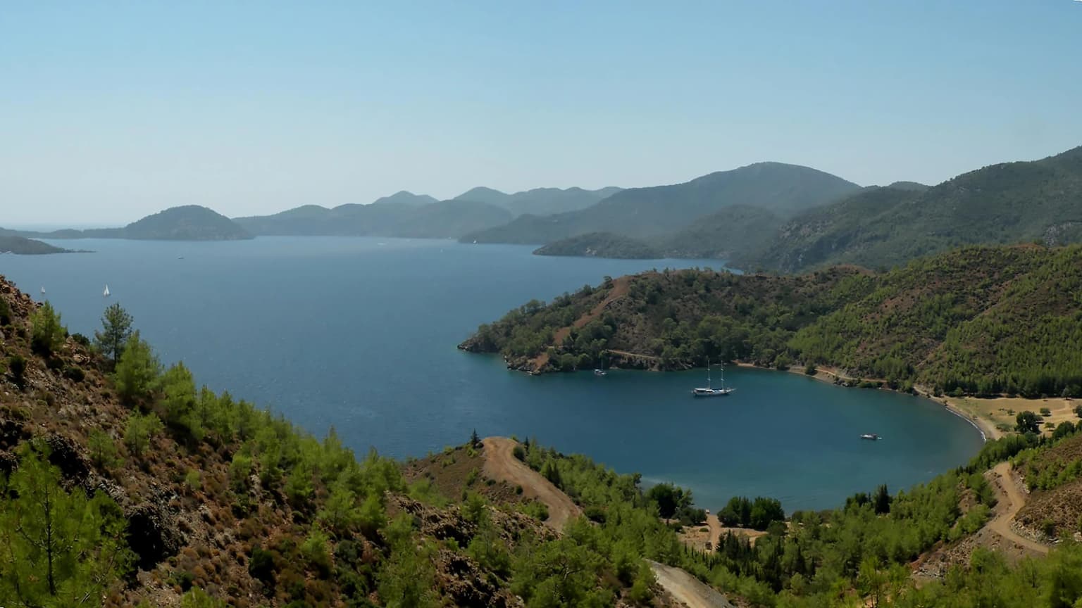 Göcek ve Dalaman arasındaki Kille Koyu'nun tepeden görünümü; geniş plajı ve çam ormanları. Tekne turları ve kampçıların favori noktası.