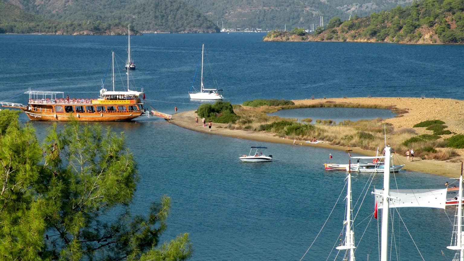 Ein kleines Fischerboot, das vor der Küste der Yassıca-Inseln in Göcek segelt. Ein authentischer lokaler Moment auf der Route der Blauen Reise.