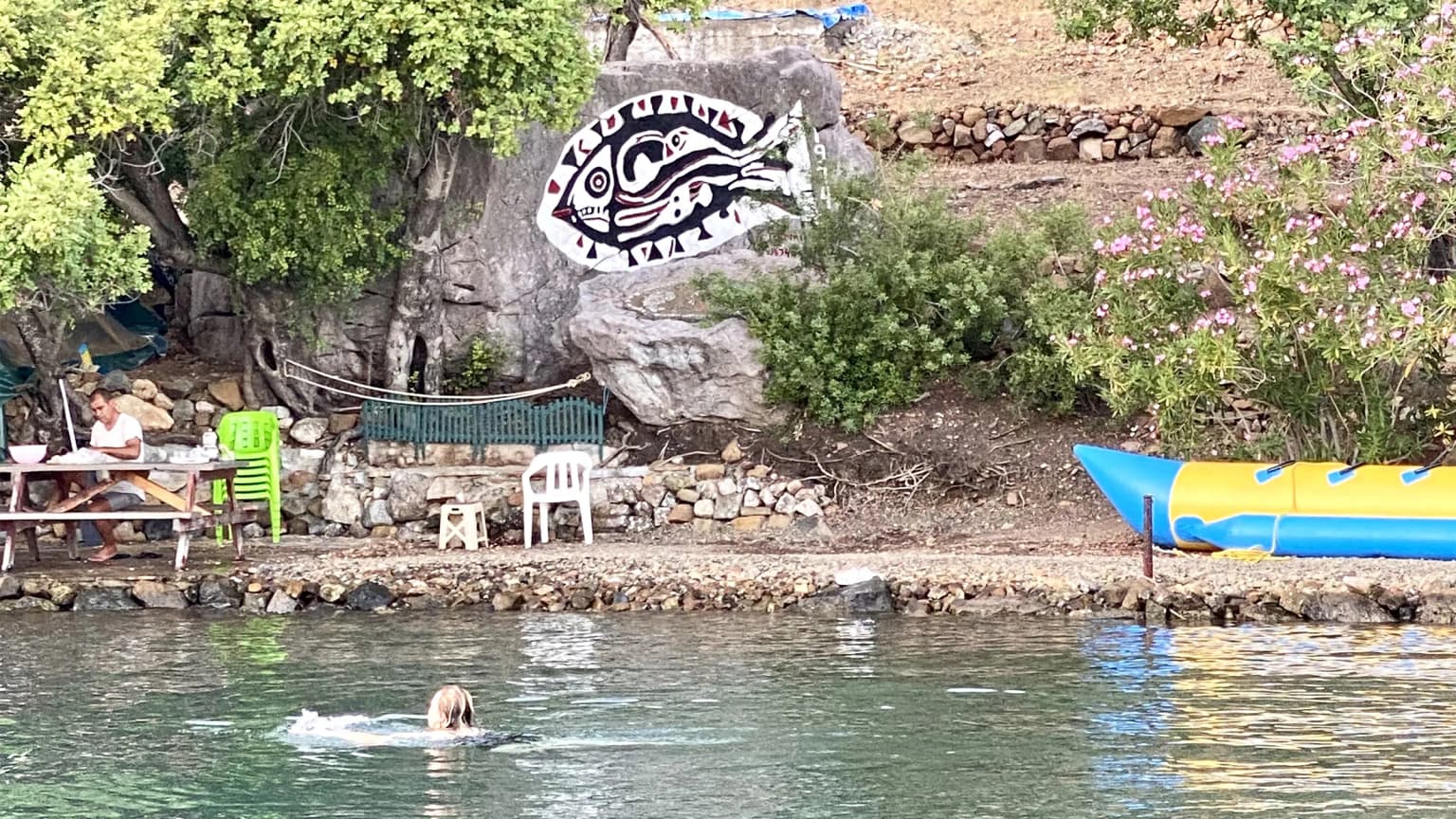 The famous fish figure drawn on a rock by the artist Bedri Rahmi in Göcek. An iconic stop for Gocek boat tours and blue cruise routes.