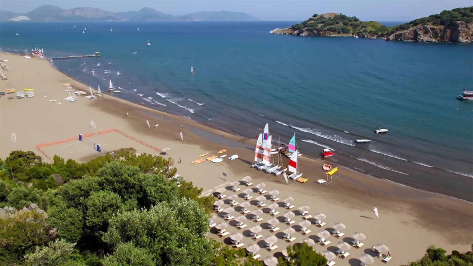 The golden sands and shallow sea of Sarigerme Beach in Ortaca, Mugla. A wide, public, Blue Flag beach, ideal for families with children.