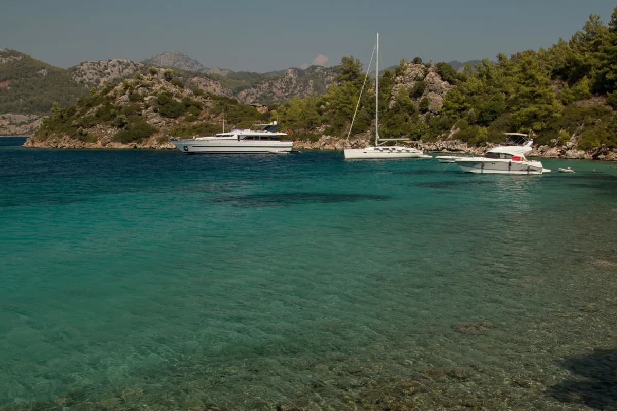 Göcek'teki Cennet Koyu'nun eşsiz manzarası ve turkuaz denizi. Yemyeşil doğasıyla bilinen, tekne ve yatların gözde demirleme alanı.
