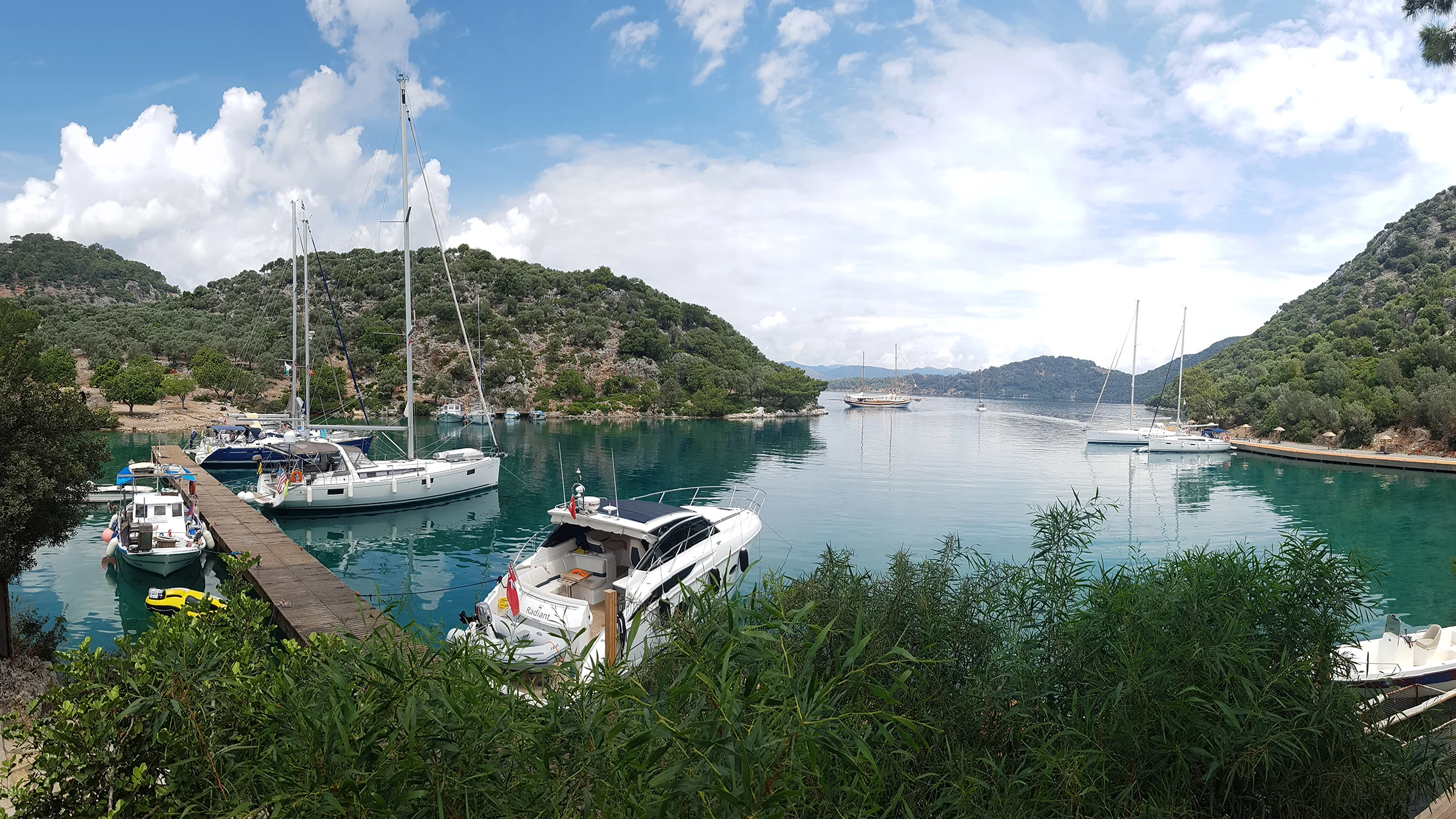 Göcek Göbün Koyu'nun dar girişi ve içerideki sakin sular. Korunaklı yapısıyla teknelerin ve yatların uğrak noktası olan restoranlı koy.