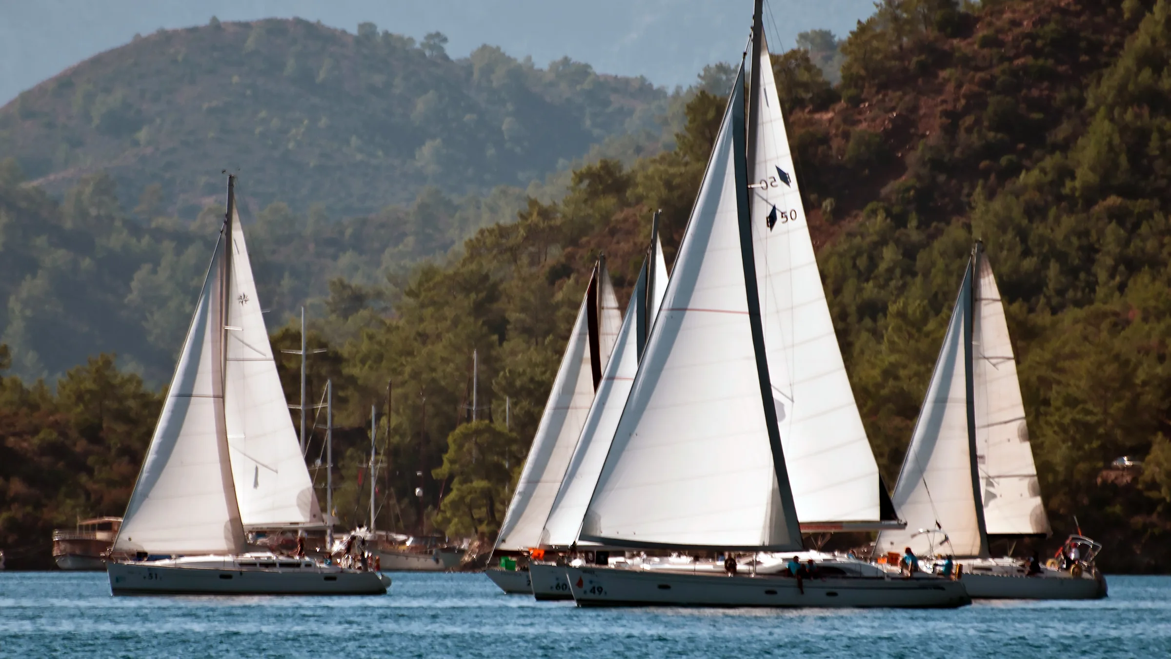 Göcek Yat Kulübü'nün (GYC) amblemi ve yelkenli yarışlarından bir an. Türkiye'nin yelken cenneti Göcek'te yelken sporunu ve yarışlarını organize eden kulüp.