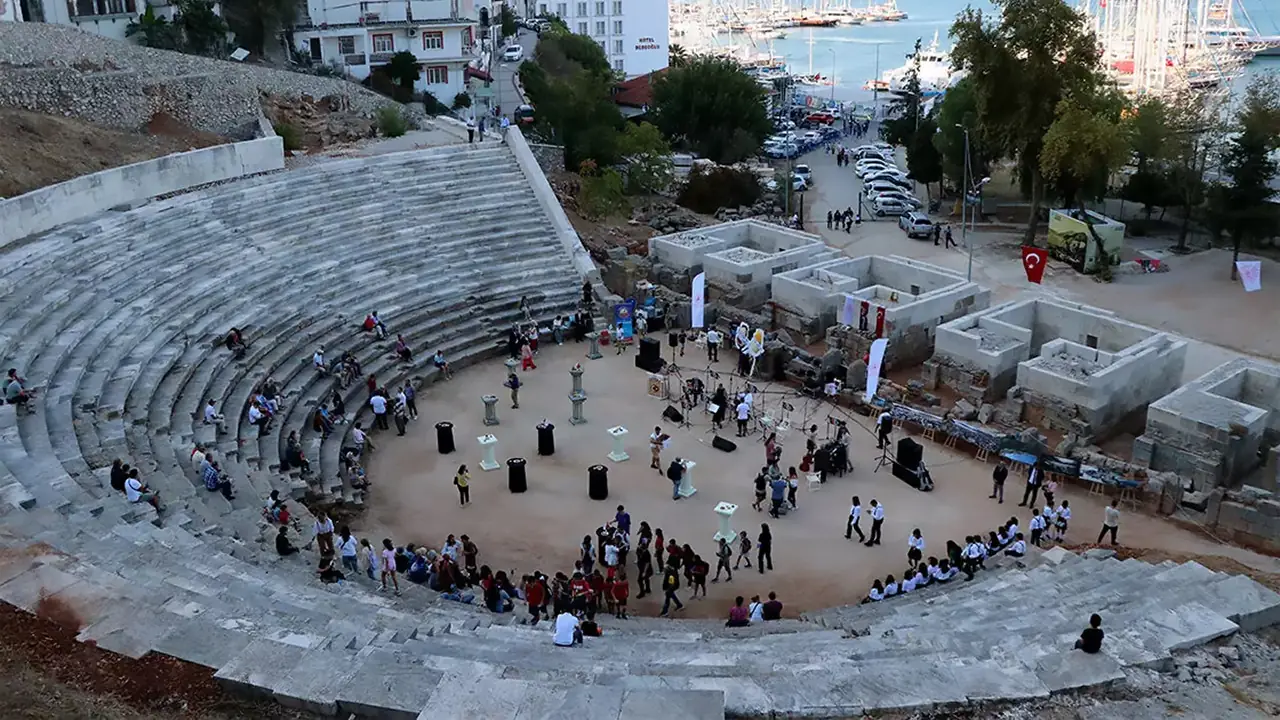 Fethiye merkezindeki Telmessos Antik Tiyatrosu ve liman manzarası. Roma döneminden kalma, günümüz Fethiye'siyle iç içe geçmiş tarihi yapı.