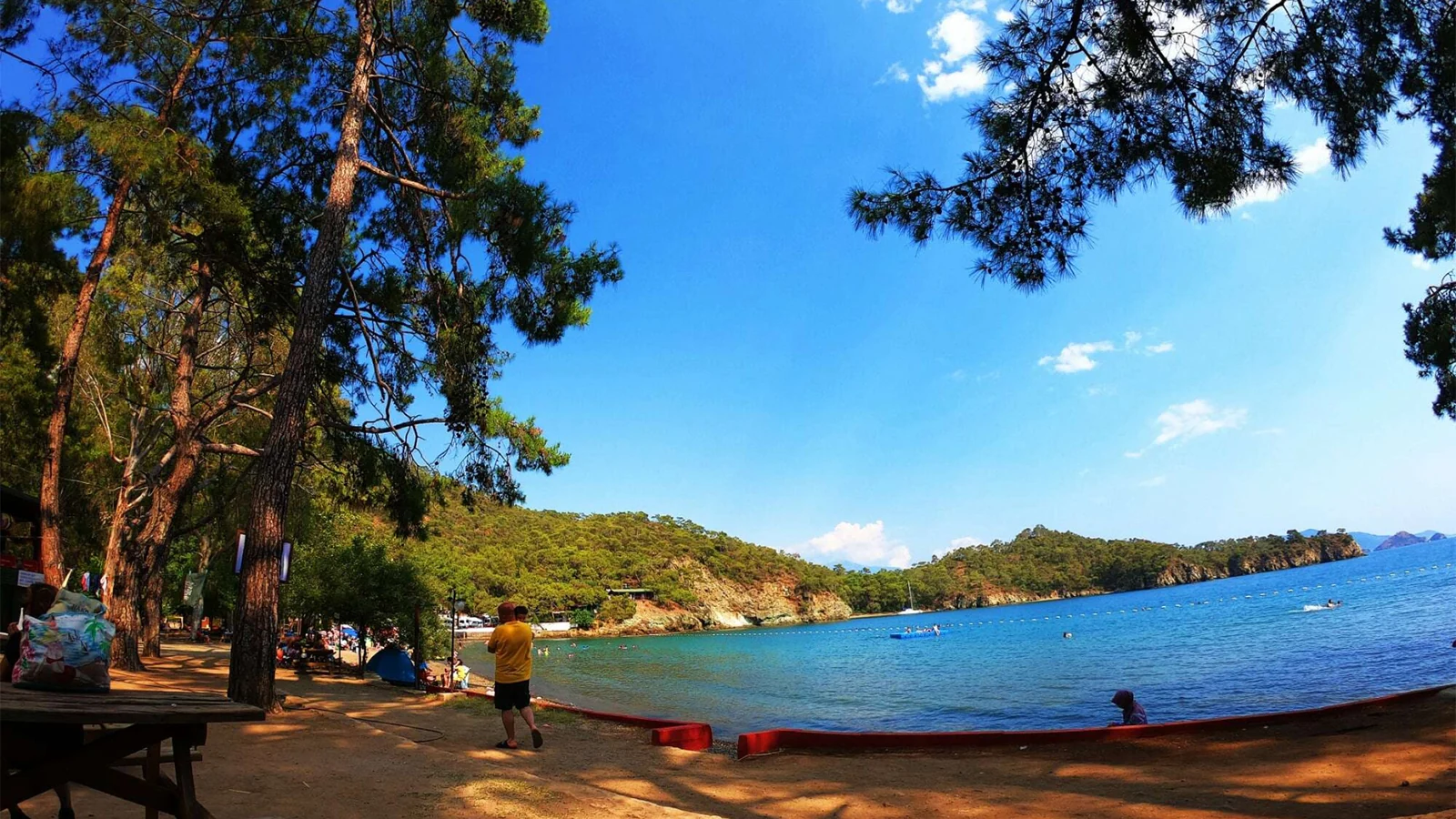 Fethiye'deki Katrancı Koyu Tabiat Parkı'nın çam ve okaliptüs ağaçları ile çevrili plajı. Karayoluyla kolay ulaşılabilen, popüler bir kamp ve günübirlik dinlenme alanı.