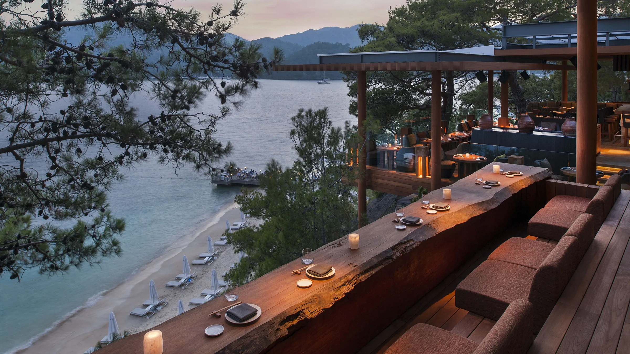 Göcek'teki Q Lounge'un terasından panoramik koy manzarası. Gün batımında tekneler ve adalarla birlikte eşsiz bir seyir keyfi.