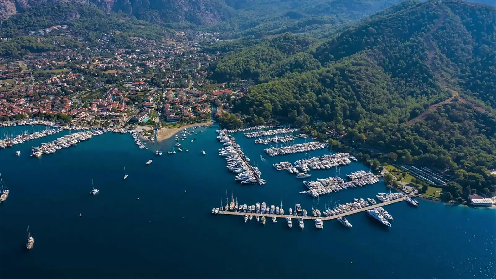 Göcek'teki D-Marin'de sıralanmış lüks yatlar ve modern marina tesisleri. Mavi yolculuk için premium hizmetler sunan, uluslararası bir yatçılık merkezi.