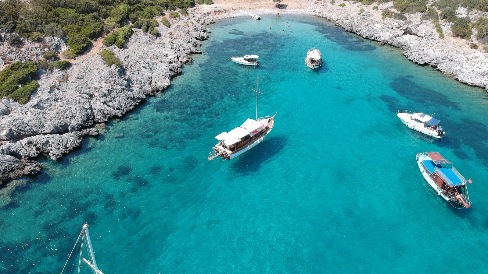Göcek'teki Akvaryum Koyu'nun havadan görünümü; berrak denizi ve tekneler. Şnorkel ve yüzme için popüler tekne turu durağı.